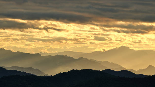 istock silhouette of mountains at sunset with a cloudy sky. 1363218897