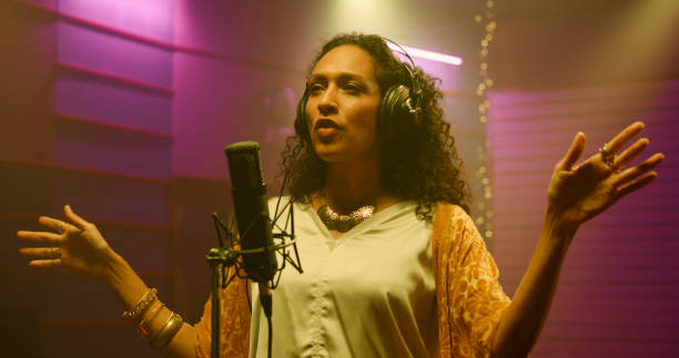 istock Female singer singing in recording studio 1363223560