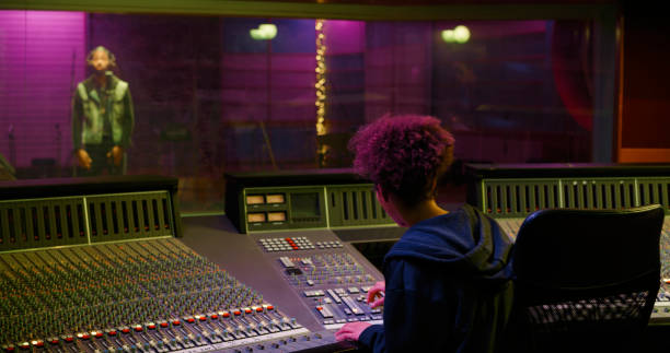 istock Female composer operating sound mixer in recording studio 1363223572