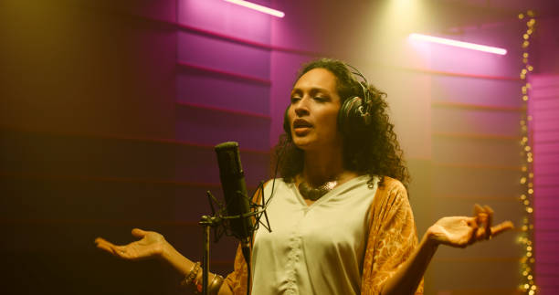 istock Female singer singing in recording studio 1363223574