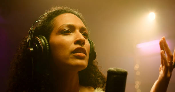 istock Female singer singing in recording studio 1363223578