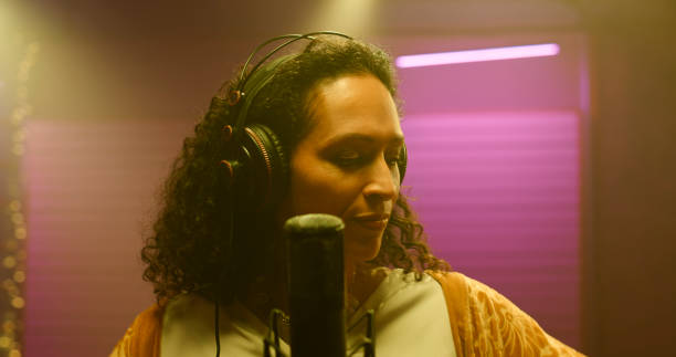 istock Female singer singing in recording studio 1363223659