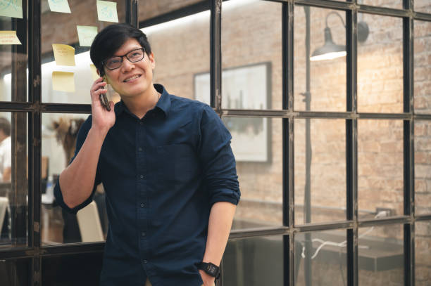 istock Happy businessman talk with smartphone in office 1363223884