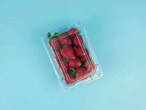 top view of strawberries in a transparent plastic container. healthy and vegetarian fruit concept.