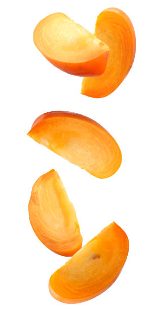 istock falling pieces of persimmon isolated on a white 1363226563