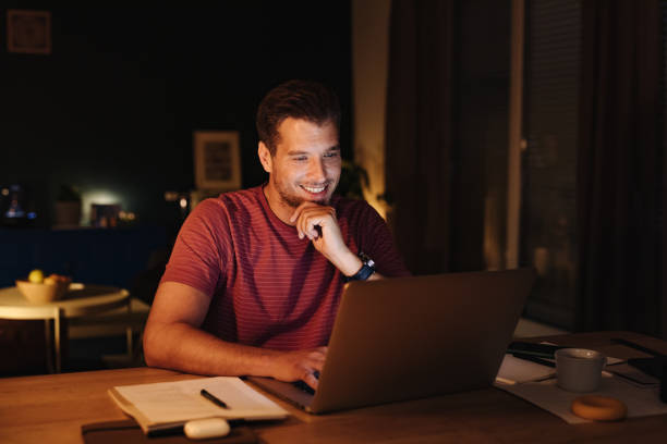 istock Smiling Businessman Working on a Laptop Computer at Night 1363227300