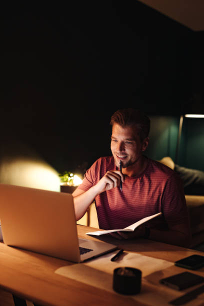 istock Smiling Businessman Working on a Laptop Computer at Night 1363227352