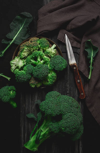 istock Fresh broccoli, on a cutting board, black background, top view, no people, vertical, 1363227594
