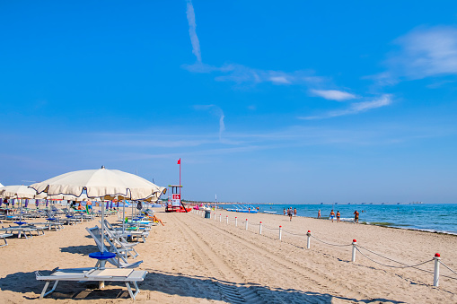 People strolling on the beach of Sottomarina, one of the destinations of summer tourism on the Adriatic riviera of Veneto