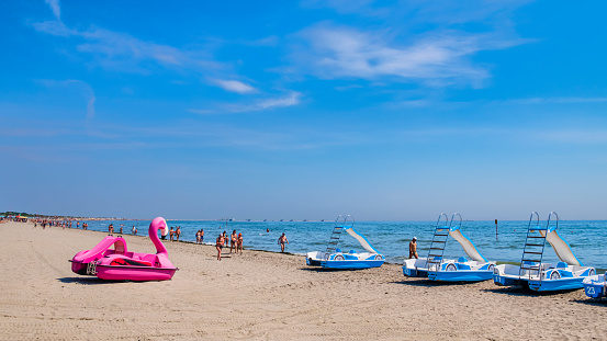 People strolling on the beach of Sottomarina, one of the destinations of summer tourism on the Adriatic riviera of Veneto