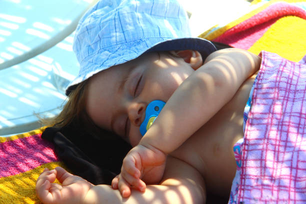 Cute baby sleeping on the beach, Turkey. stock photo