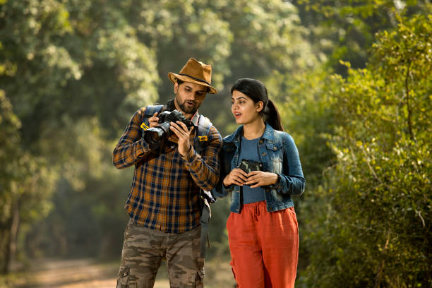 istock Couple browsing camera pictures in forest 1363232587