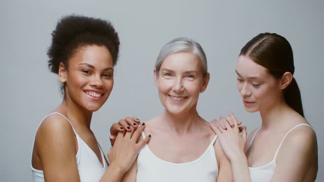 Caucasian models with large age differences stand beside African-American woman