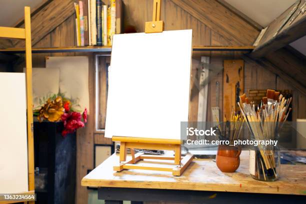 Artistic Equipment In A Artist Studio Empty Artist Canvas On Wooden Easel And Paint Brushes Retro Toned Photo Copy Space Stock Photo - Download Image Now