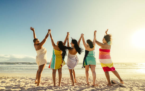 istock Young women cheering happily at the beach 1363236322