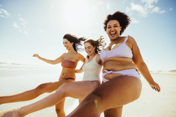 istock Three happy girlfriends having a good time at the beach 1363236359