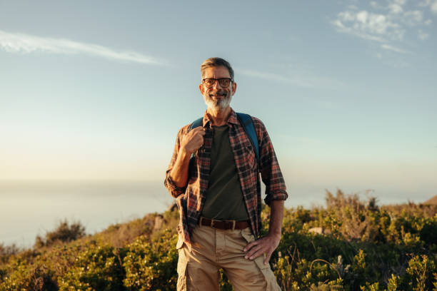 istock Male hiker smiling at the camera at sunset 1363236372