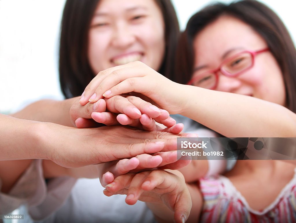 friends put hands together three people putting hands together, teamwork Achievement Stock Photo