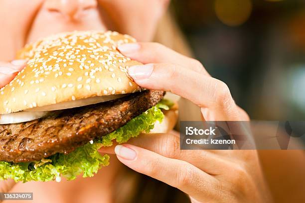 Foto de Mulher Em Um Restaurante Comer Hambúrguer e mais fotos de stock de Adulto - Adulto, Alimentação Não-saudável, Almoço