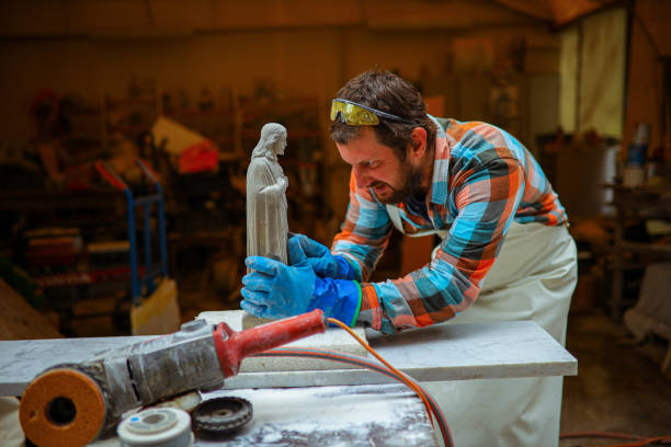 istock Dedicated male sculptor, using hand tools to carve small details on a sculpture 1363245975
