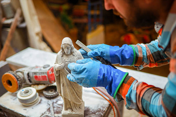 escultor masculino experto, que usa herramientas manuales para tallar pequeños detalles en una escultura - sculptor art and craft carving stone fotografías e imágenes de stock