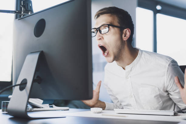 Angry office worker shouting at the computer stock photo