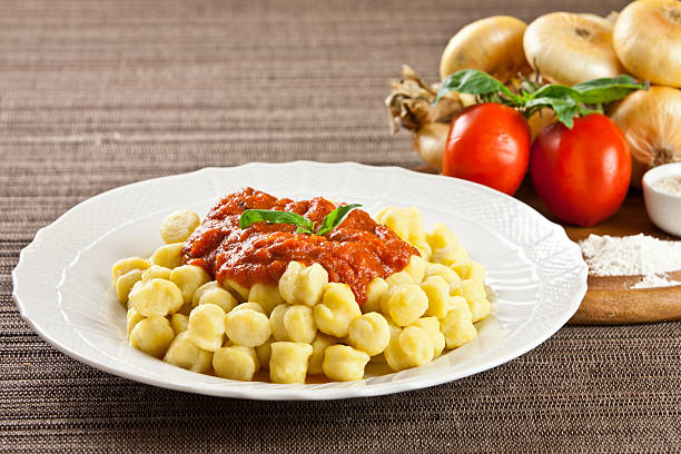 Warm plate of homemade pasta with ingredients. Tomato, onion, flour, parmesan cheese