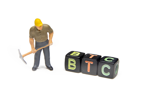 Plastic Miniature Worker With Pickaxe Looking At Bitcoin Cubes, Isolated On White Background