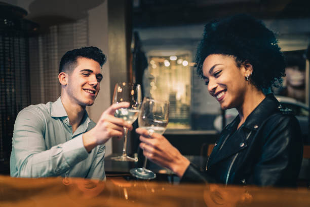 istock Romantic biracial couple toasting white wine sitting at restaurant 1363254263