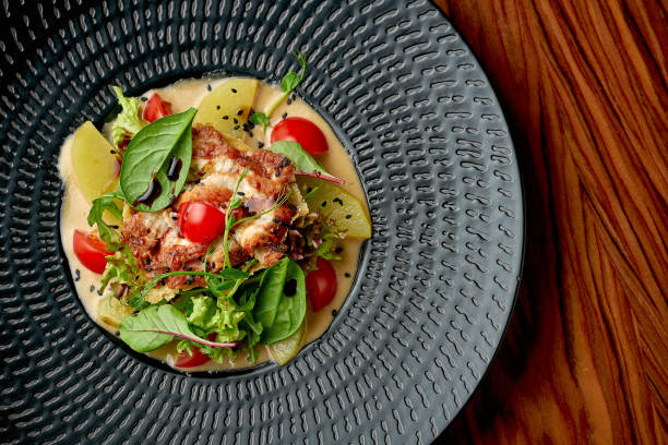 istock Salad with eel and apples in a black plate on a wooden background 1363255268