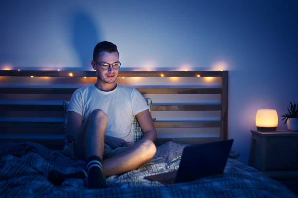 istock Man in bed watching laptop at night 1363256284