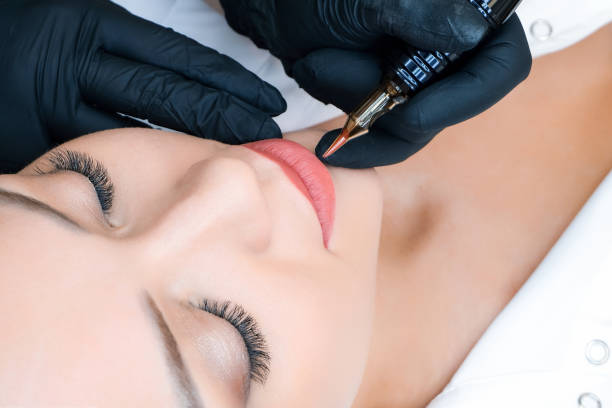 istock Young woman having permanent makeup on her lips at the beauticians salon 1363257257