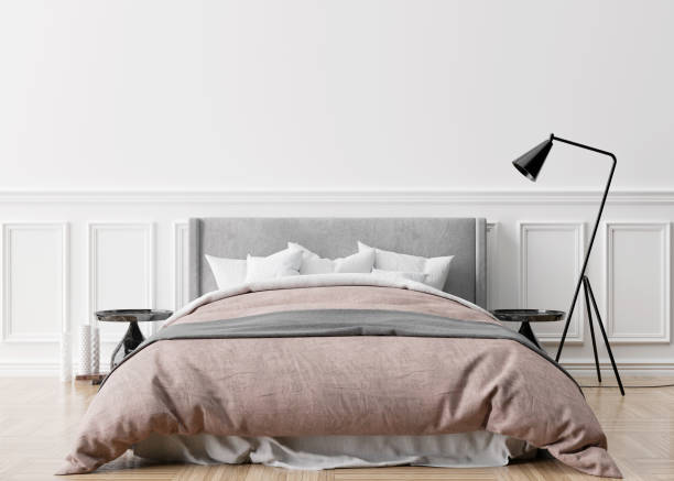 istock Empty white wall in modern and cozy bedroom. Mock up interior in classic style. Free space, copy space for your picture, text, or another design. Bed, lamp, parquet floor. 3D rendering. 1363261912