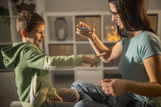 istock Mother using twine to pull out milk teeth from sons mouth 1363262906