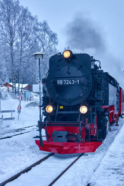 die historische dampflokomotive der harzer schmalspurbahn fährt auf den verschneiten gleisen am bahnhof vor dem brocken ein - berg brocken stock-fotos und bilder