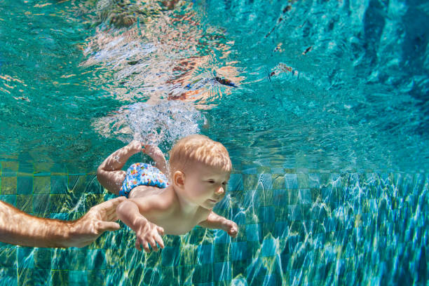 istock Happy family dive underwater with fun in swimming pool 1363264704