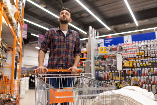 istock male shopper with a trolley oops examines racks with tools in a construction hypermarket 1363265551