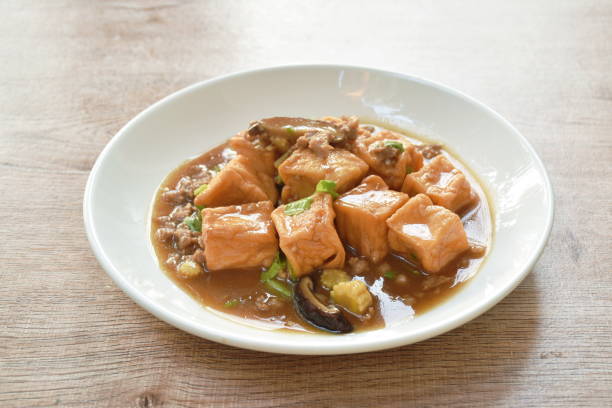 deep fried fish tofu with chop pork topping slice mushroom in sweet and sour gravy sauce stock photo