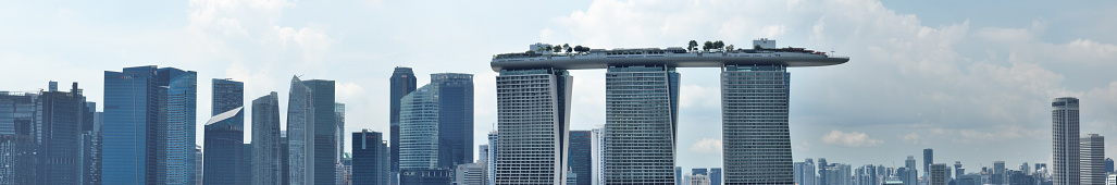 The skyline of Singapore showing the landmark of Marina Bay Sands and office building of the financial district. Seen a cloudy day in the summer.
