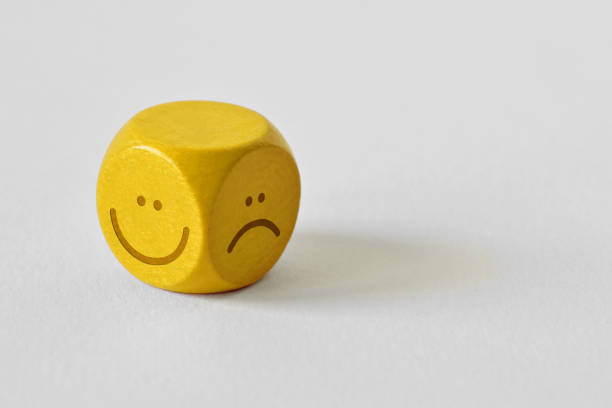 Yellow dice with positive and negative expression on white background stock photo