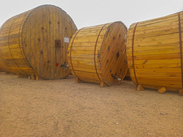 Rolls of power cables, Wooden spools of cables in desert yard. Rolls of high-voltage power cable in the oil plant power station ready to get installed. Famous place, desert. wooden spool stock pictures, royalty-free photos & images