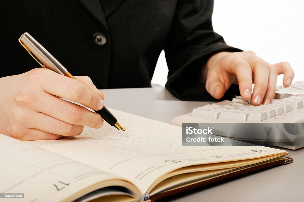 Woman writing Woman's hand holding a pen writing a text 'at' Symbol Stock Photo