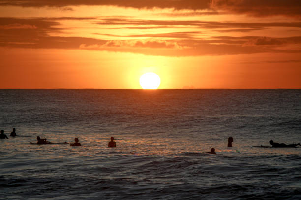 Sunset at Praia da Conceição and surfers catching the wave.