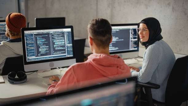 istock Smart Young Students Studying in University with Diverse Multiethnic Classmates. Scholars Collaborate in College Room on Computer Science Project, Writing Software Code in Successful Teamwork. 1363276520