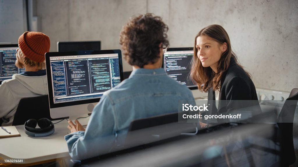 Smart Young Students Studying in University with Diverse Multiethnic Classmates. Scholars Collaborate in College Room on Computer Science Project, Writing Software Code in Successful Teamwork. Computer Programmer Stock Photo