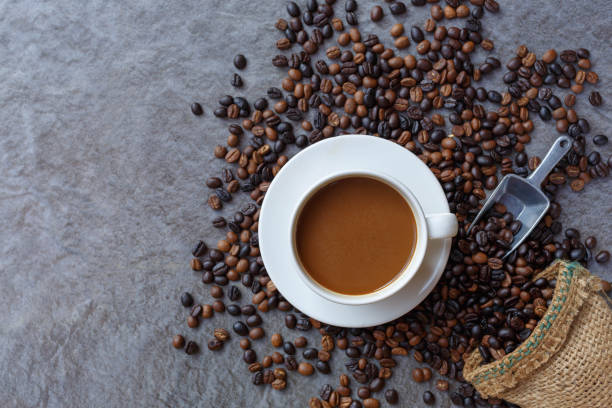 istock Coffee cup and roasted coffee beans in brown bag, top view. 1363276590