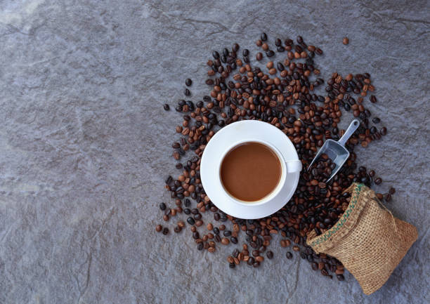 istock Coffee cup and roasted coffee beans in brown bag, top view. 1363276593