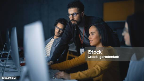 Lecturer Helps Scholar With Project Advising On Their Work Teacher Giving Lesson To Diverse Multiethnic Group Of Female And Male Students In College Room Teaching New Academic Skills On A Computer Stock Photo - Download Image Now