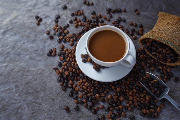 istock Coffee cup and roasted coffee beans in brown bag, top view. 1363276614