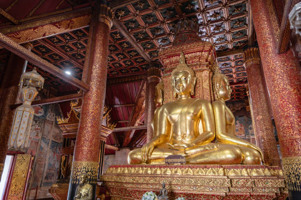 estátua de buda dourada em wat phumin na cidade de nan tailândia. wat phumin é o templo mais atraente da cidade de nan. - phumin - fotografias e filmes do acervo
